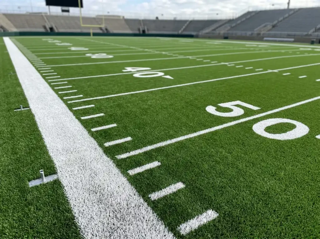 NFL gridiron field with handicap point spread numbers displayed at the sideline